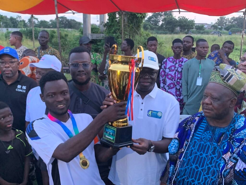 Joueur de Zoungbomè soulevant le trophée de champion du tournoi TOVI-NONVI aux côtés de l'honorable Louis Koukpemedji et des autorités d'Akpro-Missérété
